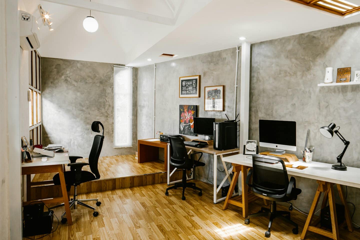 Ufficio moderno e vuoto con postazioni minimaliste e pavimenti in legno.
